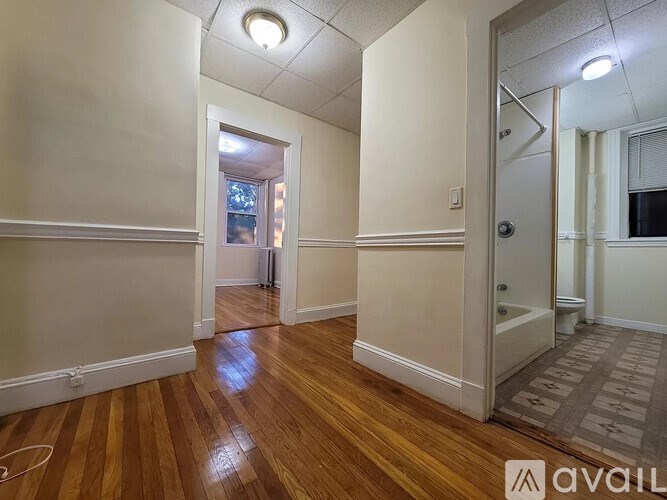 A hallway with wooden floors and white walls.