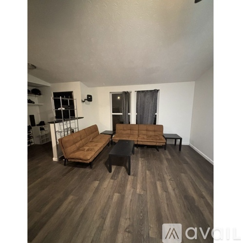 A living room with a brown couch and a black coffee table.