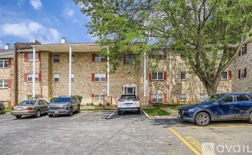 A parking lot with cars and a building in the background.