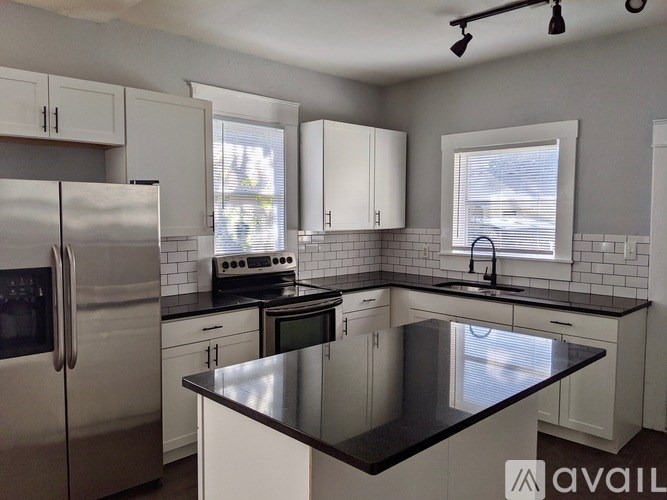 A kitchen with black countertops and white cabinets.