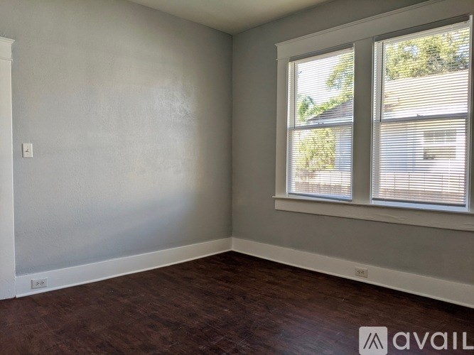 A room with a window and a wall socket.