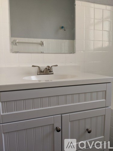 A bathroom sink with a white counter top and a mirror above it.