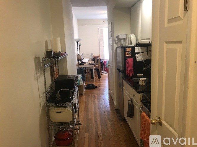 A kitchen with a white door and a white wall.