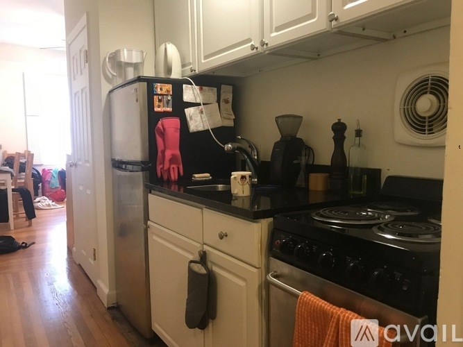 A kitchen with a black stove and white cabinets.