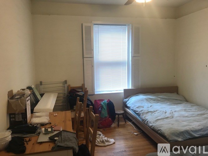 A bedroom with a bed, desk, and chair.