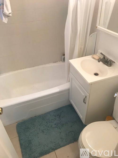A bathroom with a white tub, sink, and toilet.