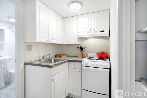 A small kitchen with white cabinets and a white stove.