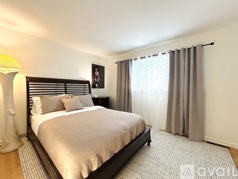 A bedroom with a large bed and a blue carpet.