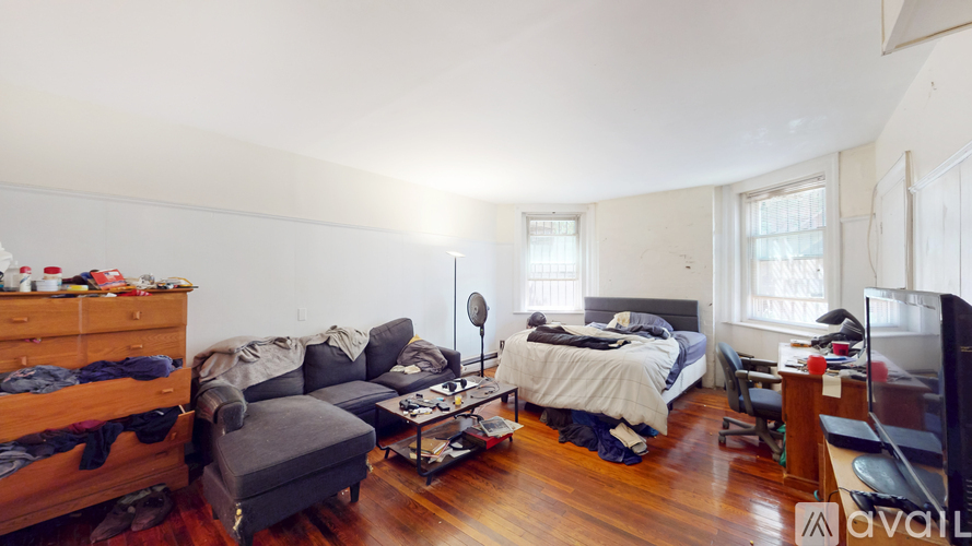 A bedroom with a bed, a couch, and a chair.