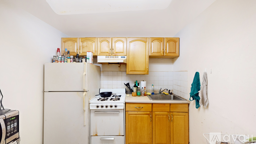 A kitchen with wooden cabinets and white appliances.