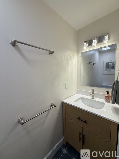 A bathroom with a white sink and a mirror.