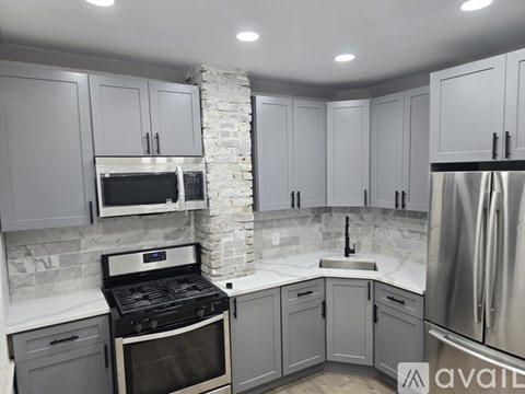 A kitchen with a stone pillar and a black stove top oven.
