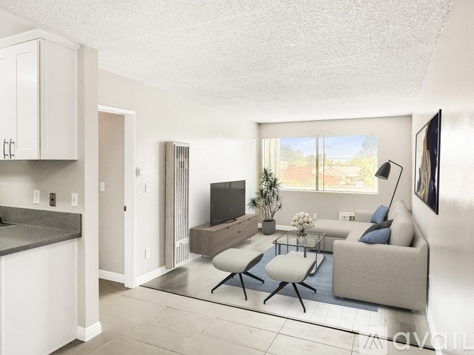 A living room with a grey couch, a coffee table, and a television.