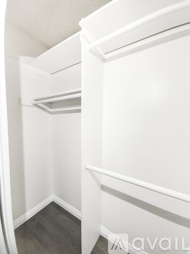 A white closet with a shelf and a white door.