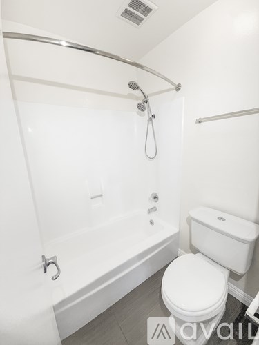 A white toilet sits next to a bathtub in a bathroom.