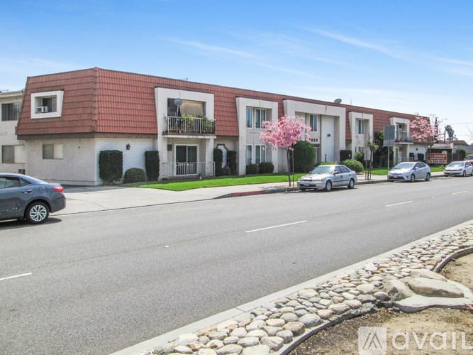 A row of houses with cars parked in front.