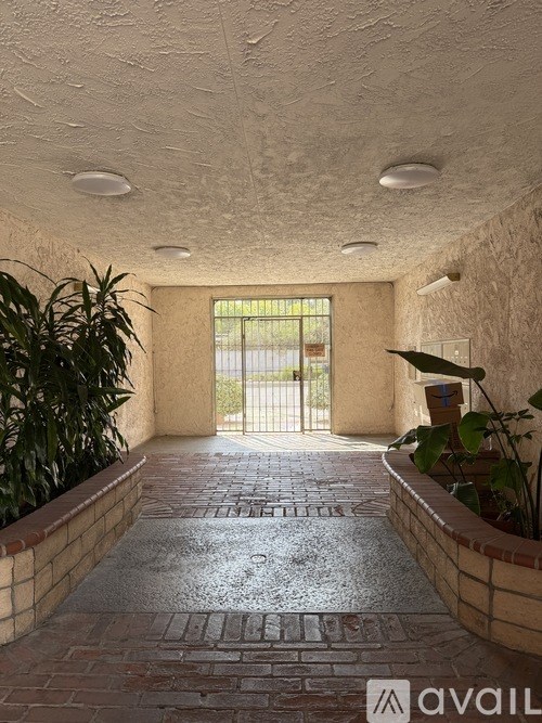 A hallway with a brick floor and a door at the end.