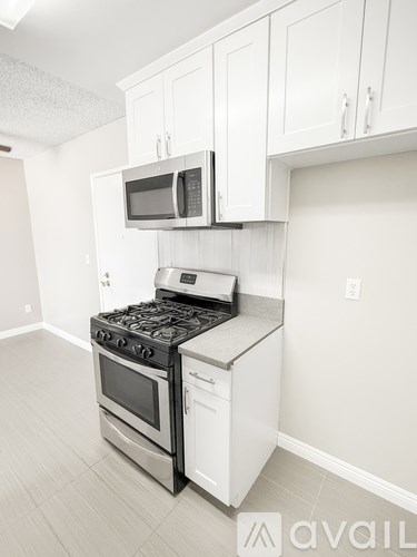 A kitchen with a stove, oven, and microwave.