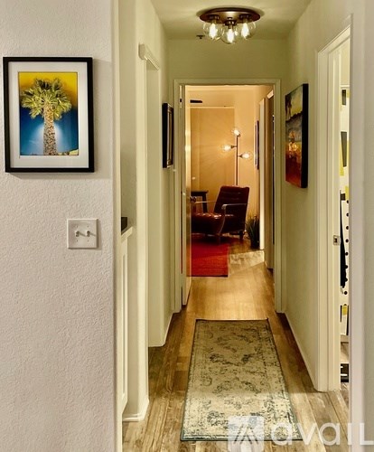 A long hallway with a picture of a palm tree on the wall.