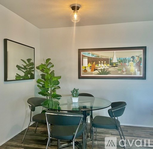 A modern dining room with a glass table and chairs.