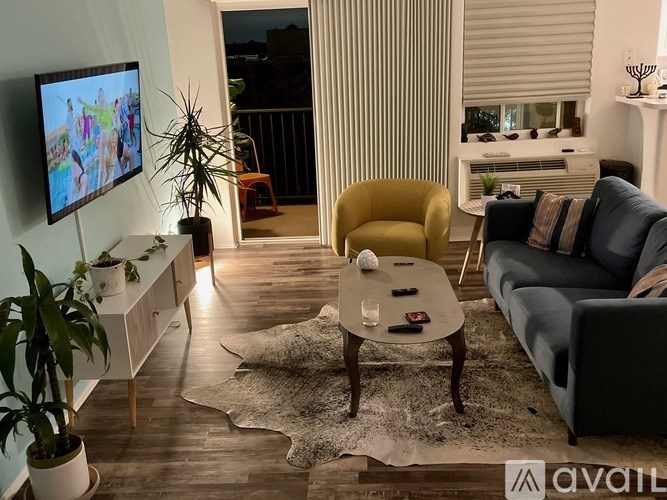 A living room with a yellow chair and a grey couch.