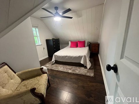 A bedroom with a white bed and a red anchor headboard.