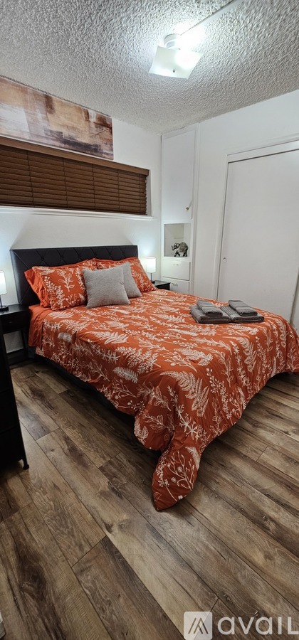 A bedroom with a bed and a painting on the wall.
