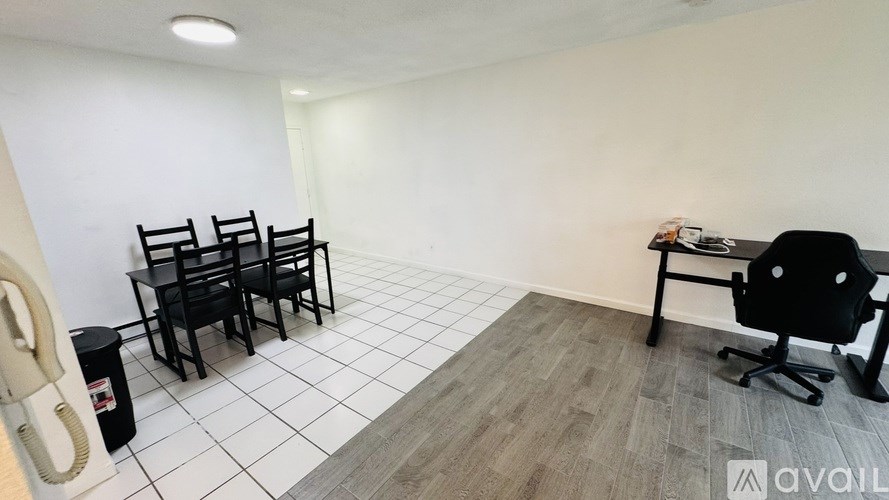 A room with a phone, chairs, and a desk.