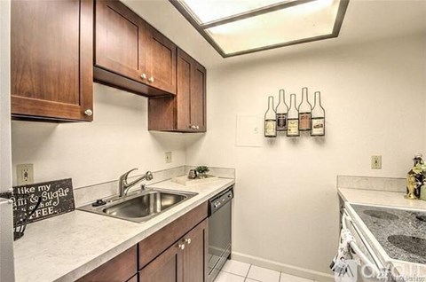 A kitchen with wooden cabinets and a black sign that says "like my Buddha in FREE".