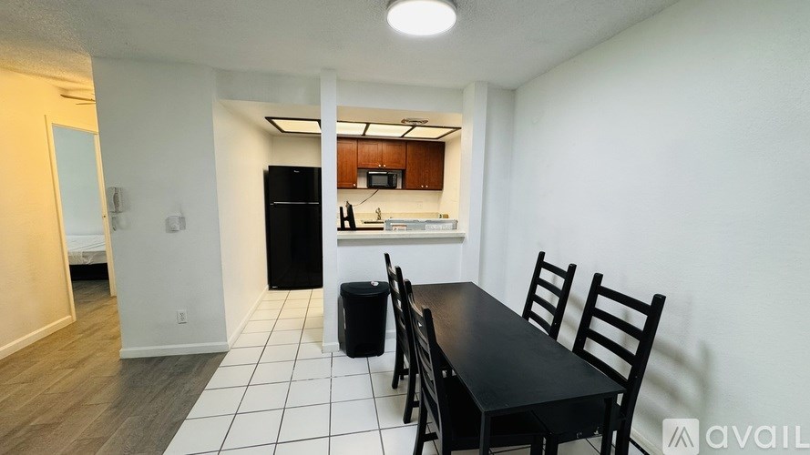 A kitchen with a black table and chairs.