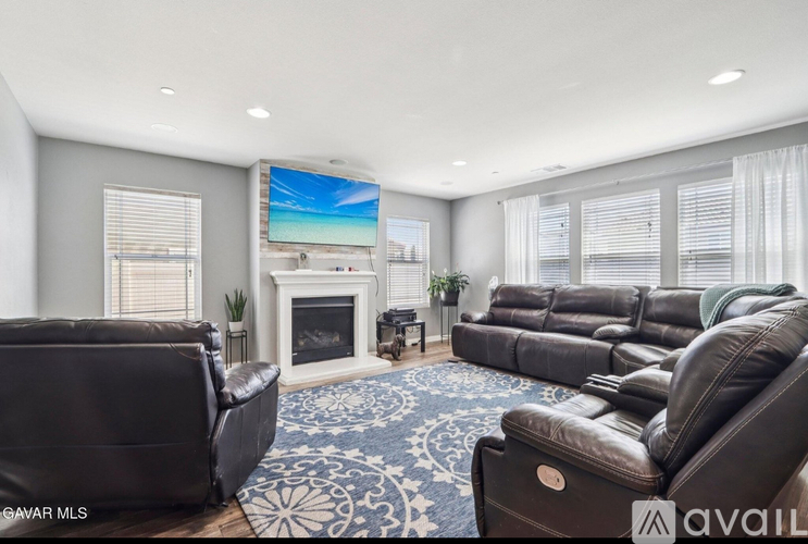 A living room with a fireplace and a large screen TV.