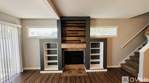 A modern living room with a fireplace and a staircase.