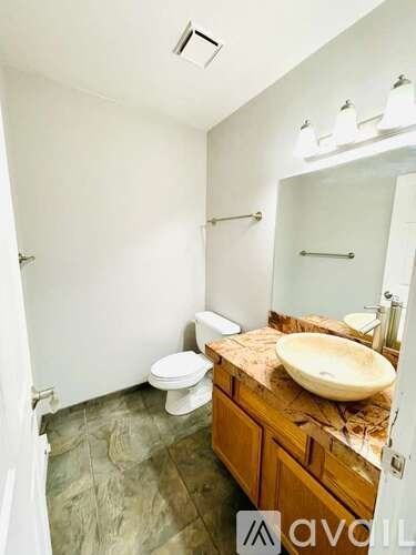 A room with a carpeted floor and a window with blinds.