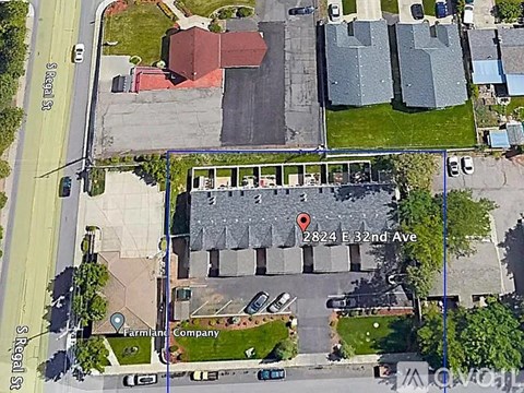 An aerial view of a street with a red marker indicating a specific location.