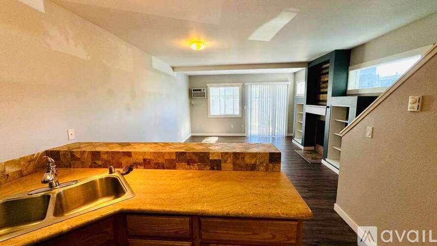 A spacious living room with a staircase leading to the upper floor.