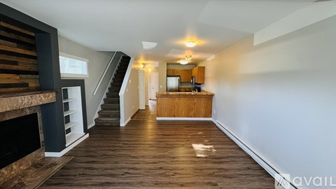 A spacious living room with a staircase leading to the upper floor.