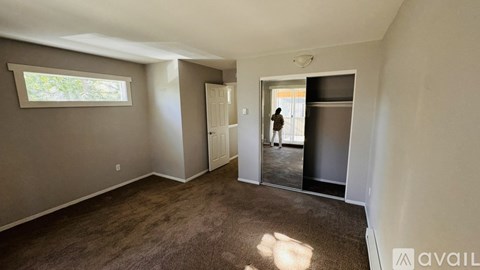 A room with a carpeted floor and a large mirror on the wall.
