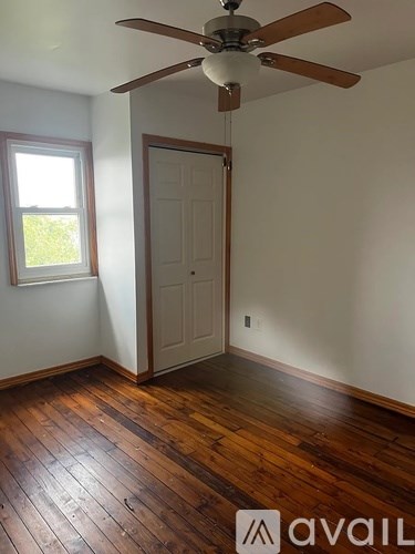 A room with a wooden floor and a ceiling fan.