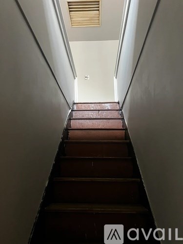 A staircase with a wooden floor and a metal railing.