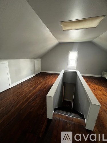 A room with wooden floors and a skylight.