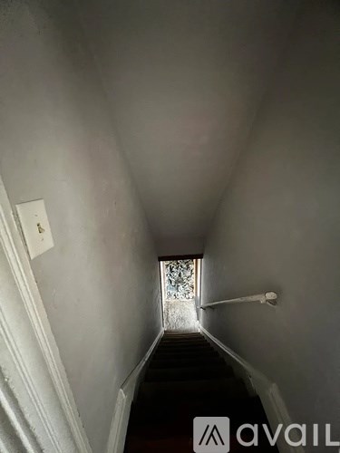 A narrow hallway with a light switch on the wall.