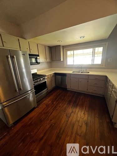 A kitchen with wooden floors and stainless steel appliances.