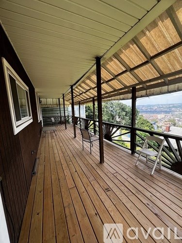 A wooden deck with a table and chairs overlooking a cityscape.