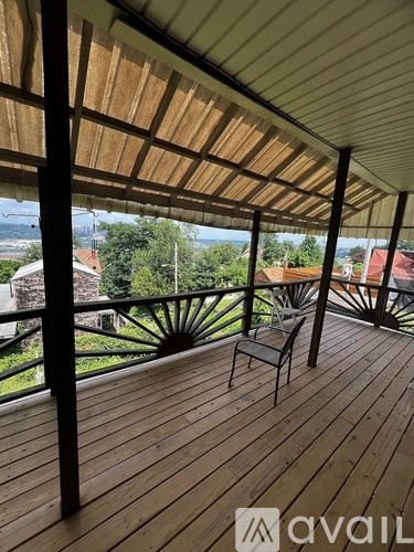 A wooden deck with a table and chairs under a roof.