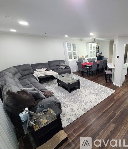 A living room with a grey sofa and a glass coffee table.