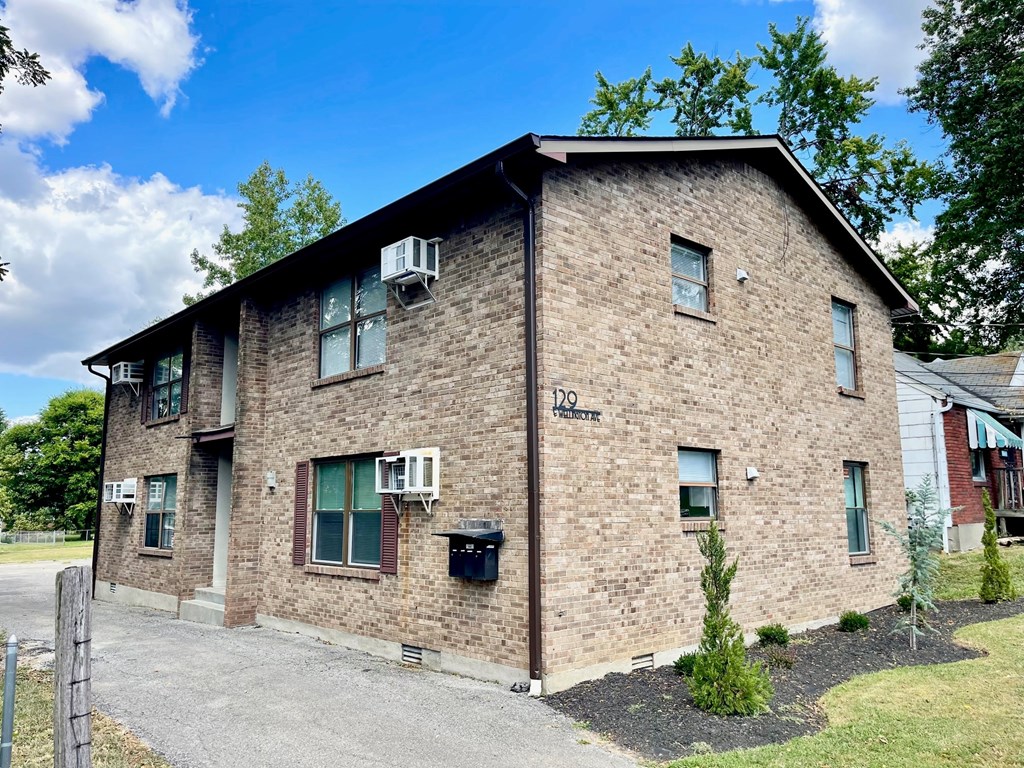 A brick building with a sign that says "102" on it.