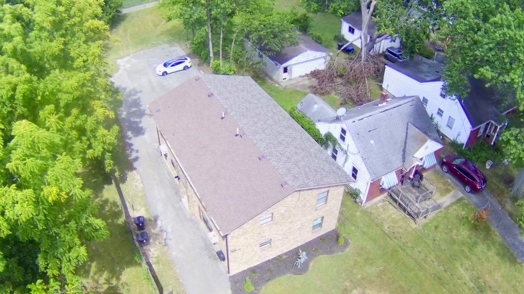 A house with a brown roof is surrounded by trees.