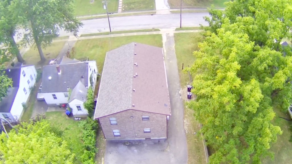 A house with a brown roof is surrounded by trees.