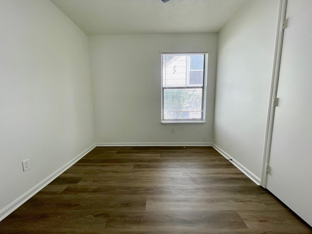 Empty room with wooden floor and a window.