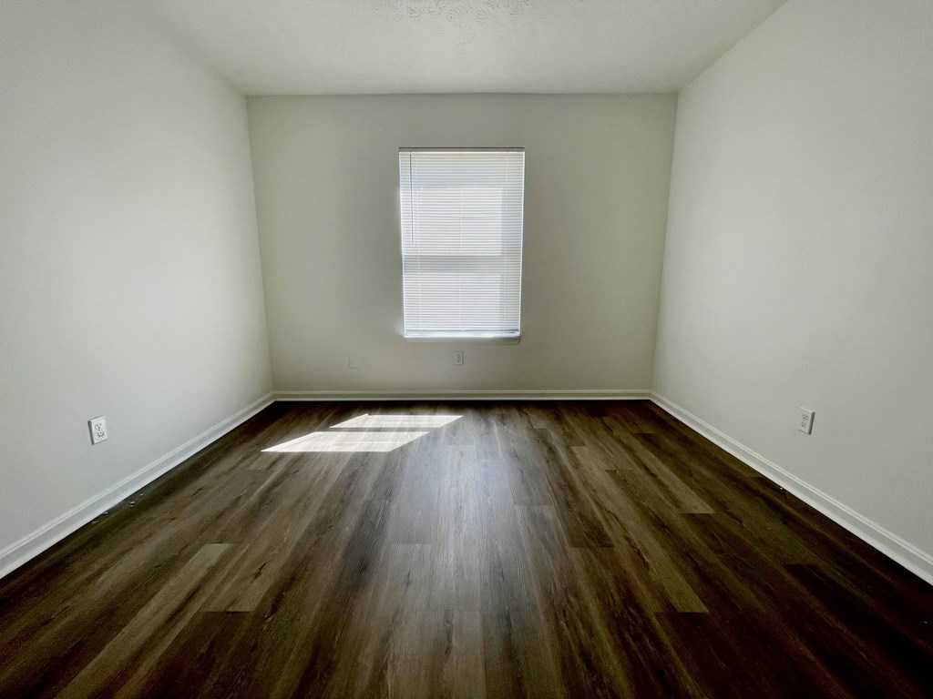 A room with wooden floors and a window.